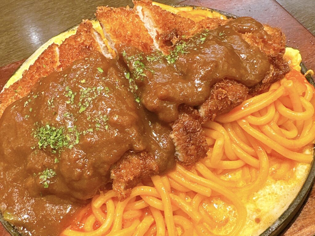 鉄板に盛り付けられたナポリタンとカツの熱々洋食